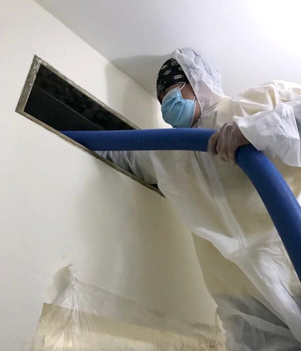 Checking a split unit with a manifold gauge, this technician performs precise HVAC work for AC cleaning Dubai residents trust