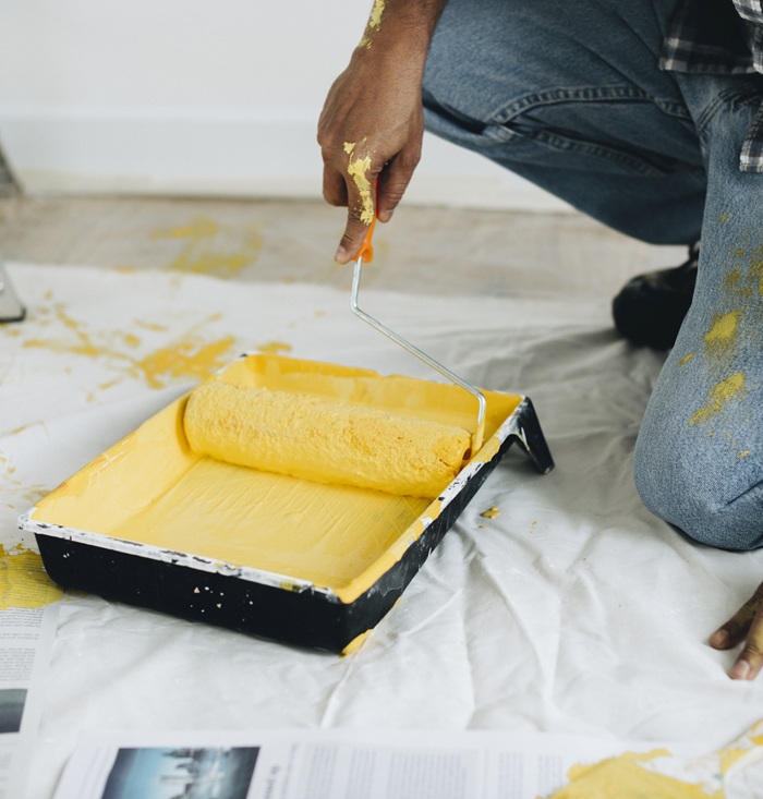 Man painting the walls yellow