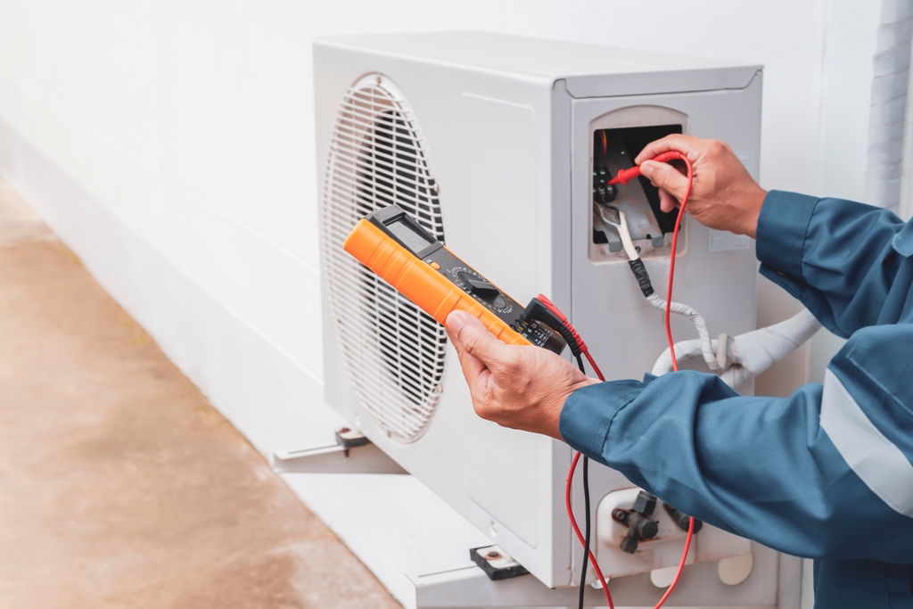 An Adams Care technician checking the unit with tools, helping maintain performance and determining how long do AC units last