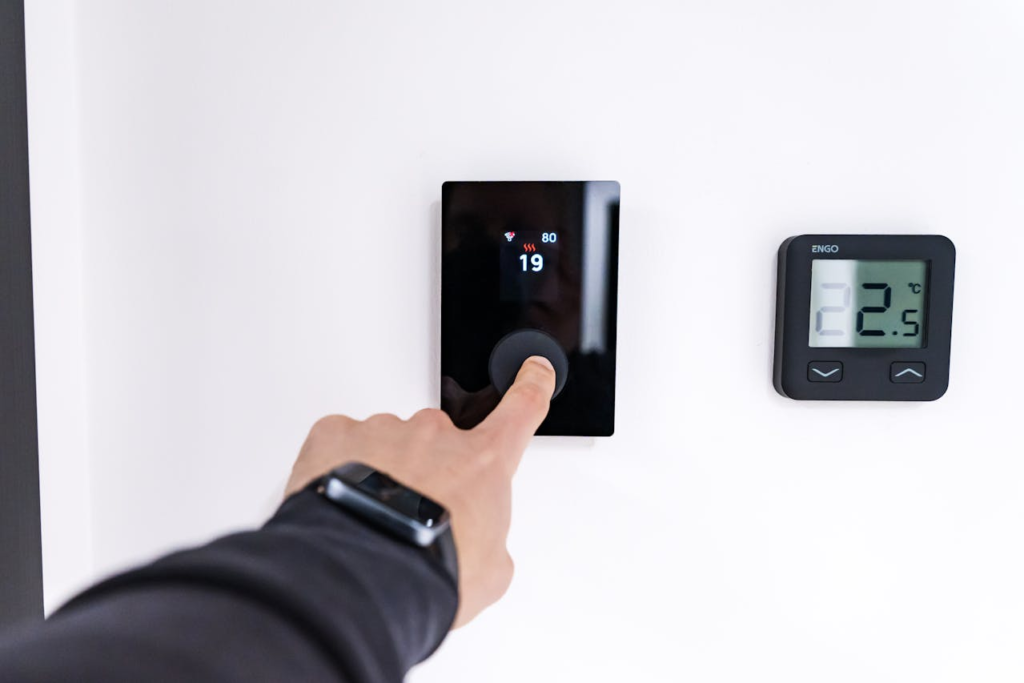 Man adjusting his digital thermostat.